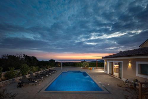 a swimming pool in a yard with chairs and a house at Villa Vilani Spa & Pool - Happy Rentals in Crikvenica