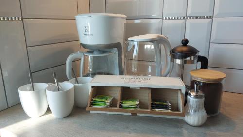 a kitchen counter with a coffee maker and cups at Apartmány U Obory in Nechánice