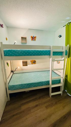 une chambre avec deux lits superposés dans une pièce dans l'établissement Charmant appartement classé et son jardin à 2 pas de la plage - AC Fibre Parking, à La Grande Motte