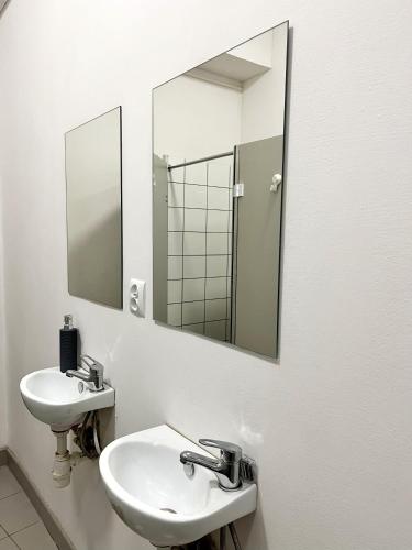 a bathroom with a sink and a mirror at TomTom Hostel in Krakow