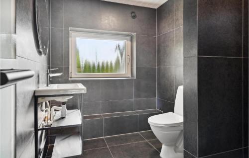 a bathroom with a toilet and a window at Cozy Home In Asperup With Sauna in Asperup