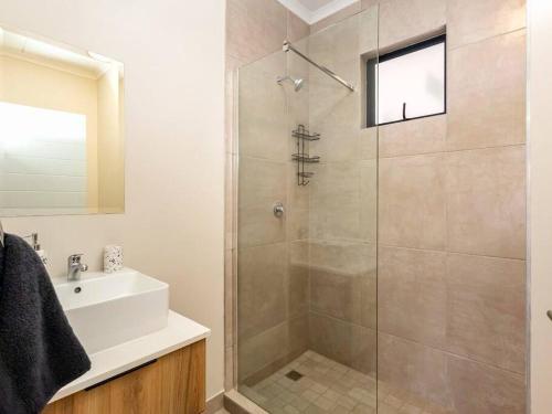 a bathroom with a shower and a sink at Urban Retreat in Midrand
