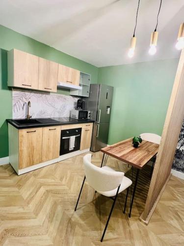 une cuisine avec une table en bois et une table et des chaises dans l'établissement Nid cosy au cœur de Martigues, à Martigues