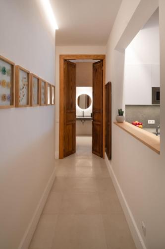 a hallway leading to a kitchen with wooden doors at Panasco Real Suite - Panasco Suites in Arrecife