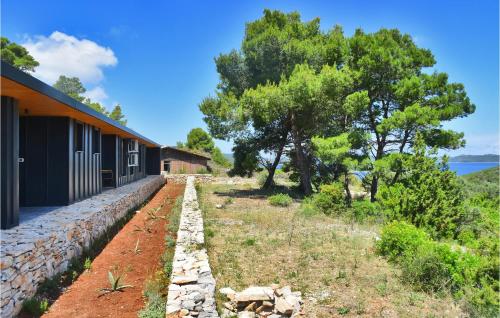 a house with a stone wall next to a building at Awesome Home In Dragove With Wifi in Dragove