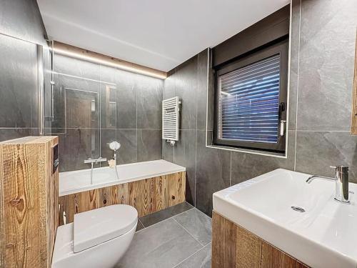 ヴェルビエにあるVerbier Le Rouge superb 3-room apartment near slopes & ski-liftのトイレ、洗面台、浴槽を備えたバスルーム