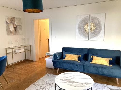 a living room with a blue couch and a table at Montreux Central Boutique Apartment Lake View and Terrace in Montreux
