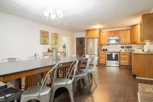 a kitchen with a long table and chairs in it at Family Home and Studio by Brick and Home in Taylors