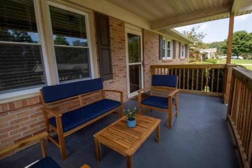 a porch with two benches and a coffee table at Family Home and Studio by Brick and Home in Taylors