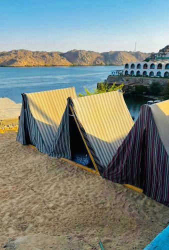 two tents on the beach with the water at Heissa Hostel in Aswan