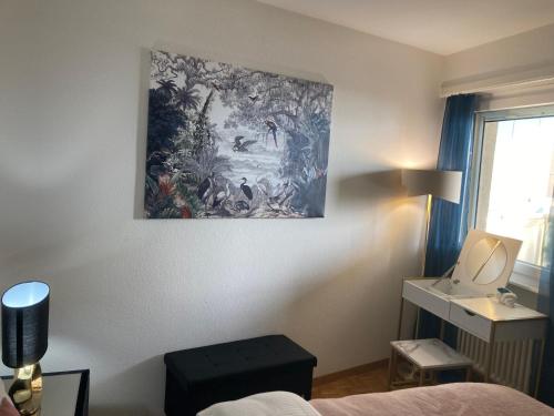 a bedroom with a painting hanging on the wall at Montreux Central Boutique Apartment Lake View and Terrace in Montreux