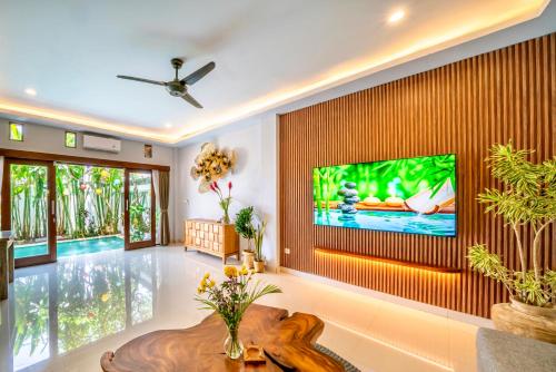 a living room with a large tv on a wall at Villa Chelsea in Canggu