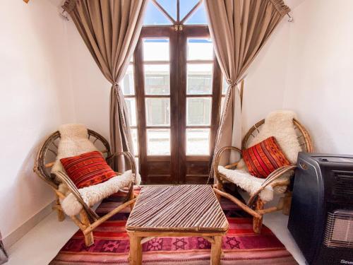 a room with two chairs and a table and a window at Hotel Nido del Flamenco in Uyuni