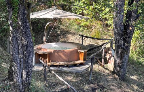 San MassimoにあるLa Casa Nel Boscoの2本の木の隣に傘付きの温水浴槽