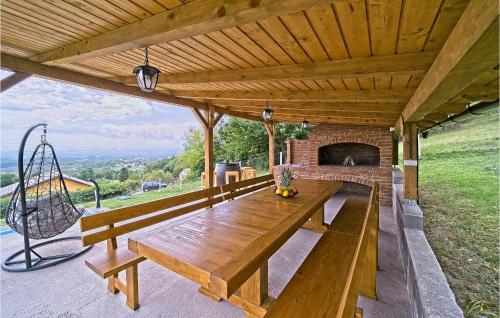 a patio with a wooden table and a fireplace at Lovely Home In Dragovanscak in Slavetić