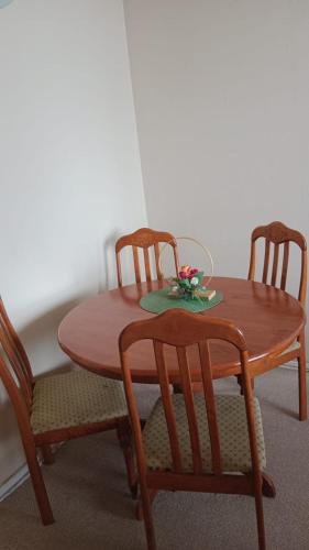 a wooden table with two chairs and a table with flowers on it at don federico tome in Tomé