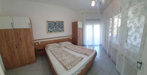 a bedroom with two beds and a wooden cabinet at Apartment in Zamardi - Balaton 53129 in Zamárdi