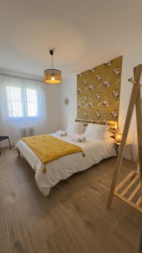 a bedroom with a large bed with a yellow blanket at Le Clos Du Moulin 3, villa jardin, 3 chambres, près d'Avignon en Provence in Entraigues-sur-la-Sorgue