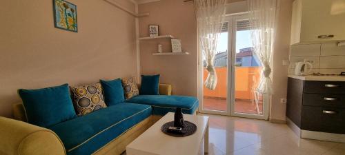 salon z niebieską kanapą i kuchnią w obiekcie Apartment Mani w mieście Ližnjan