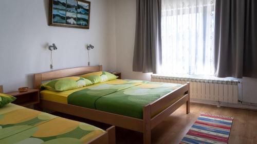 a bedroom with two beds and a window at Apartments Dar in Lokve