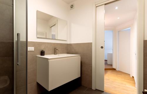 un bagno con un lavandino bianco e uno specchio di Exclusive apartment - Magritte Style a Lecco