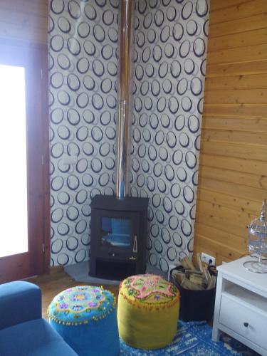 a living room with a fireplace and two ottomans at Casa dos Manos in Furnas