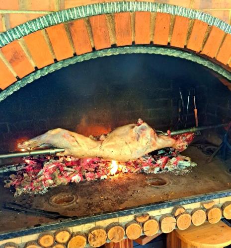 a chicken is cooking in a brick oven at Sarajevo Chalet in Hadžići
