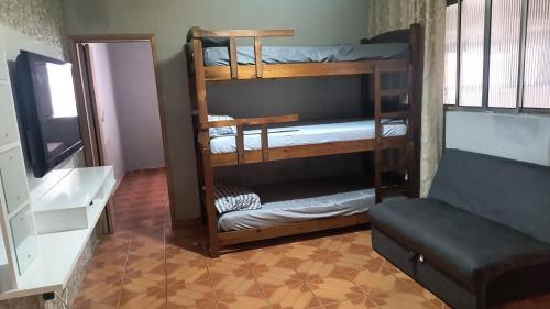 two bunk beds in a room with a couch at Expo São Paulo, casa aconchegante in Sao Paulo