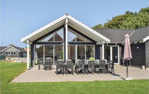 a patio with a bunch of chairs and an umbrella at Holiday Home Kronens Have Tranekær Iii in Hou