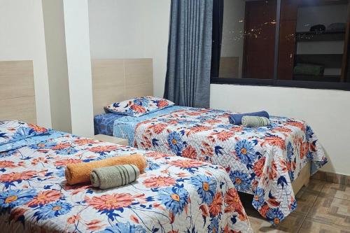 a room with two beds with colorful sheets at Espacioso y lindo lugar in Bello