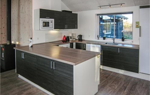 a kitchen with black cabinets and a wooden counter top at Holiday Home Kronens Have Tranekær Iii in Hou