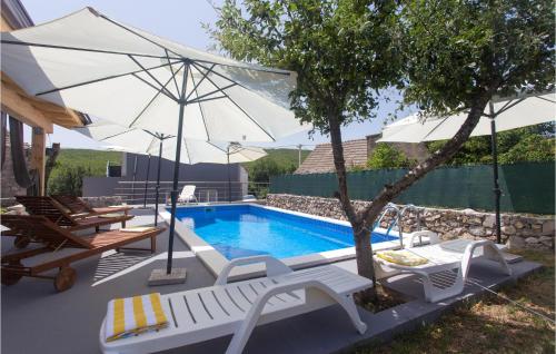 a swimming pool with chairs and an umbrella next to a pool at 3 Bedroom Stunning Home In Tijarica in Vukići