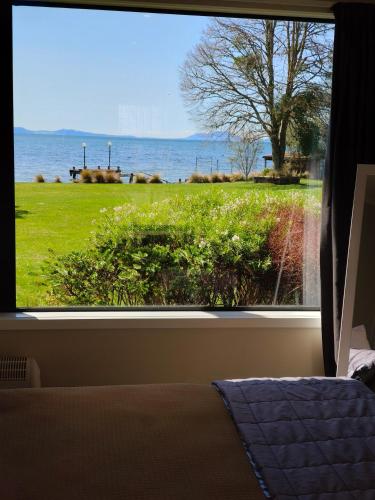 a bedroom window with a view of the ocean at Braxmere Lodge in Turangi