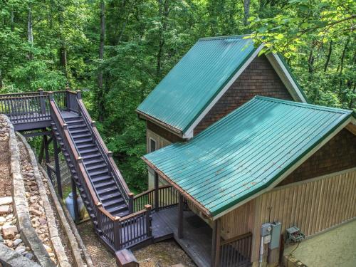 Cabaña con escalera y techo verde en Smokies Bungalow chalet, en Gatlinburg
