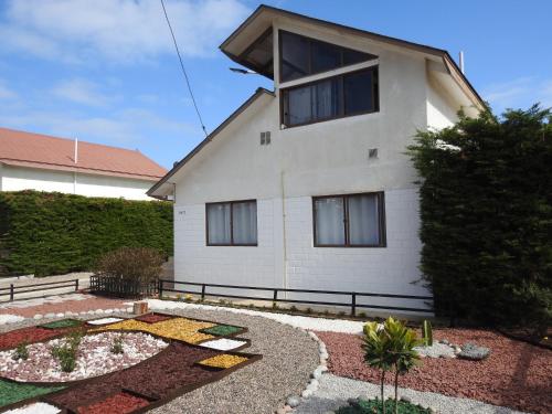 a white house with a garden in front of it at Agradable Casa en Condominio Prados del Mar Tongoy RENOVADA in Tongoy