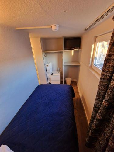 a bedroom with a blue bed and a window at Hotel Bristol in Luxembourg