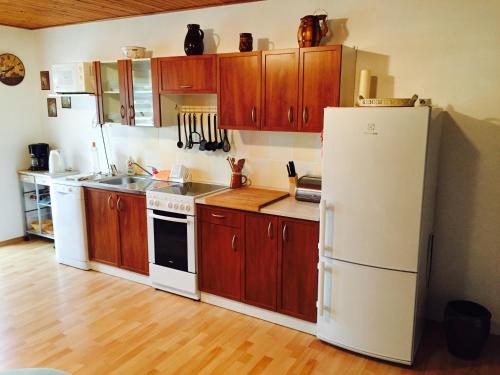 a kitchen with wooden cabinets and a white refrigerator at Apartment U Anděla in Dlouhá Ves