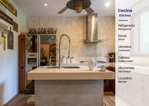 Luxury Villa in Cozumel with Pool & Hot Tub في كوزوميل: مطبخ مع حوض وطاولة عمل مع ملصقات