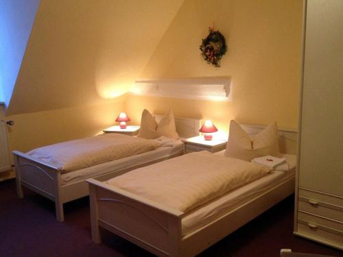 two beds in a room with two lamps on them at pension & sauna AM LORENZ in Calbe