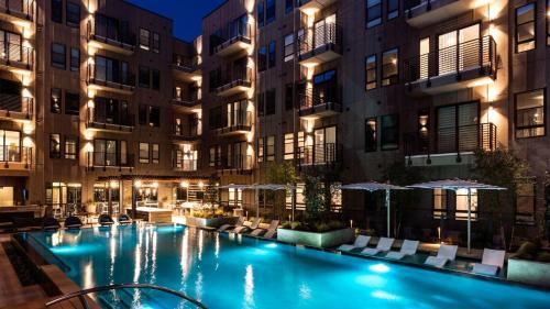 ein Schwimmbad vor den Gebäuden in der Nacht in der Unterkunft Cityscape Luxury Living Downtown Fort Worth Condo, Pool, Gym, Parking, BBQ in Fort Worth