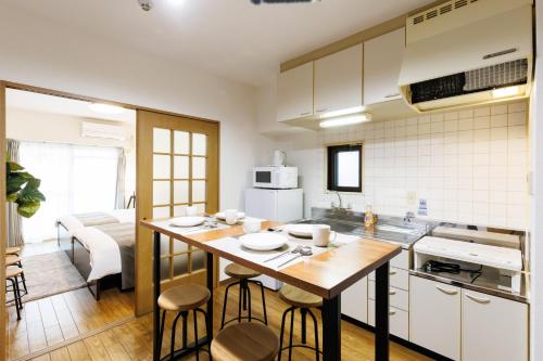 a kitchen with a table and chairs in a room at Shippo Town Hotel Nishiohashi-eki in Osaka