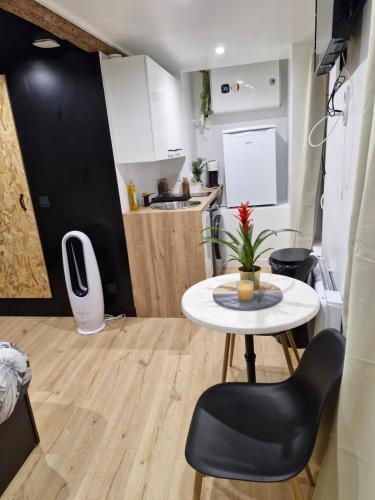 une petite cuisine avec une table blanche et une table dans l'établissement Studioroomjungle, à Béziers