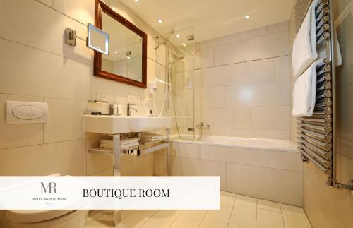 
a bathroom with a toilet, sink and bathtub at Monte Rosa Boutique Hotel in Zermatt
