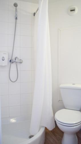 a white bathroom with a shower and a toilet at HECO Calais Centre-Gare in Calais