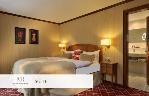 a hotel room with a bed and a bathroom at Monte Rosa Boutique Hotel in Zermatt