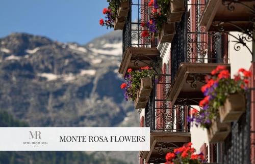 a row of balconies with flowers and a sign that reads morro rock flowers at Monte Rosa Boutique Hotel in Zermatt