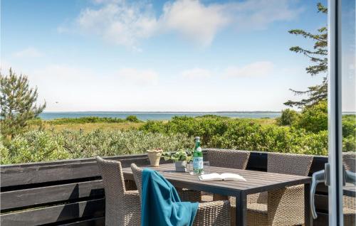 a table and chairs on a patio with a view of the ocean at Lovely Home In Nykøbing Sj With Wifi in Klint