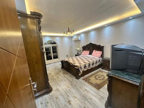 a bedroom with a bed and a flat screen tv at King Farouk Palace in Cairo