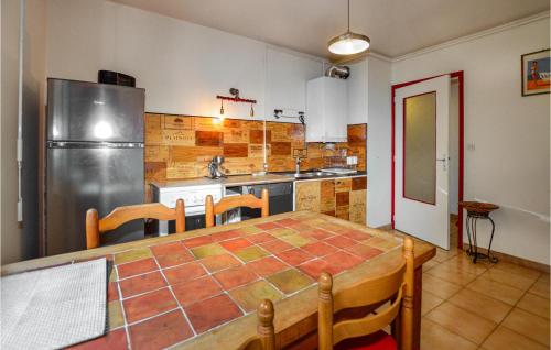 une cuisine avec une table et un réfrigérateur dans l'établissement Cozy Apartment In Ajaccio With Wifi, à Ajaccio