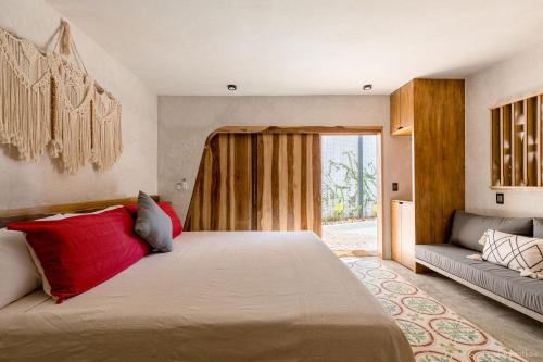 a bedroom with a large bed and a couch at Quiote Quiote in Puerto Escondido